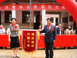 江西東芝電子材料有限公司總經(jīng)理 松木俊治 從于都縣領(lǐng)導手中接過(guò)錦旗